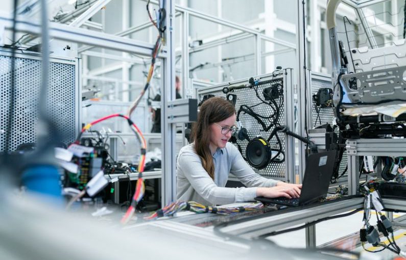 Manufacturing - woman in white long sleeve shirt using black laptop computer
