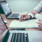 Startups Finance - person holding pencil near laptop computer