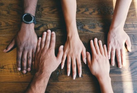 Cultural - five human hands on brown surface