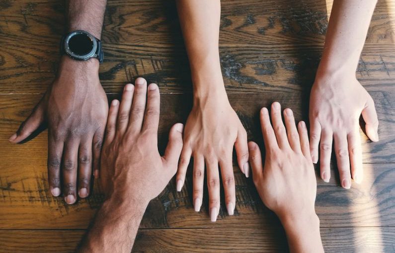 Cultural - five human hands on brown surface
