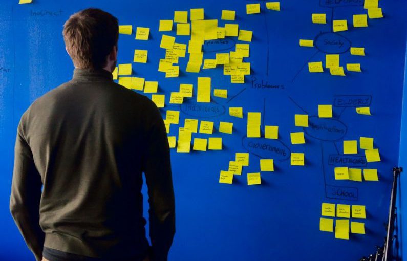 Startups - man in gray long sleeve shirt standing in front of blue and yellow puzzle mat
