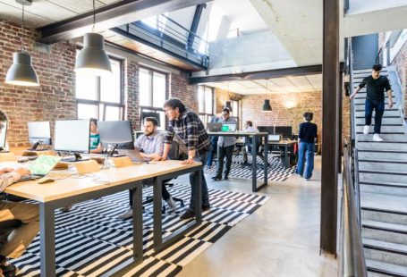 Startups - man standing beside another sitting man using computer