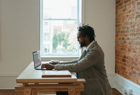Remote Work - a person sitting at a desk with a laptop and papers