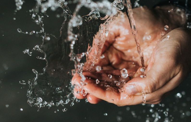 Clean Water - a person holding their hands under a stream of water