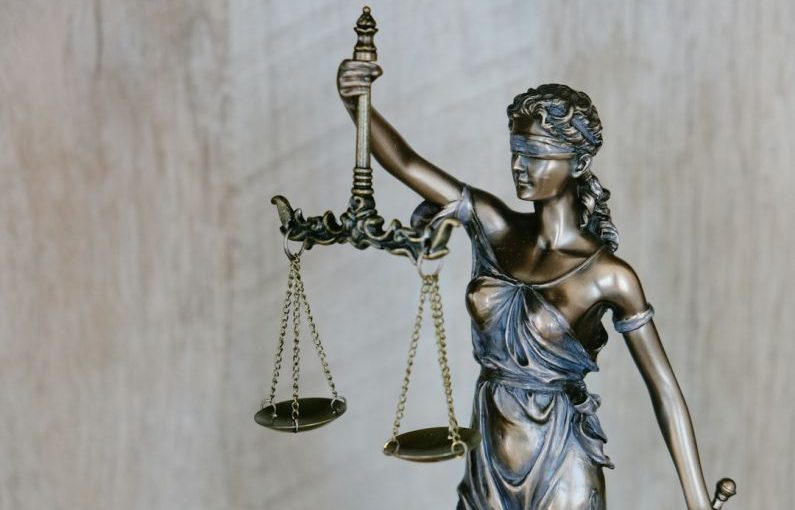Legal - woman holding sword statue during daytime