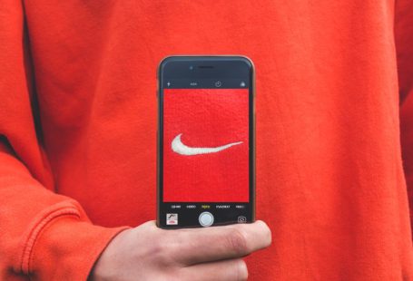 Brand - person holding iPhone taking picture on Nike label