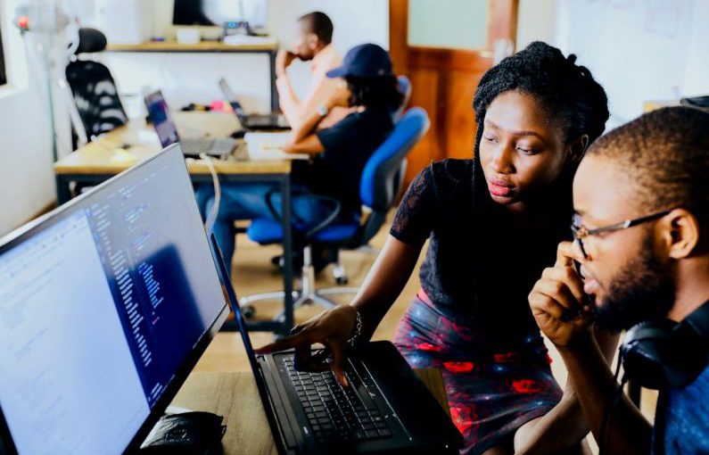 Tech Startup - woman and man sitting in front of monitor