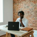 Business - a man sitting at a table in front of a laptop