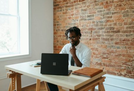 Business - a man sitting at a table in front of a laptop