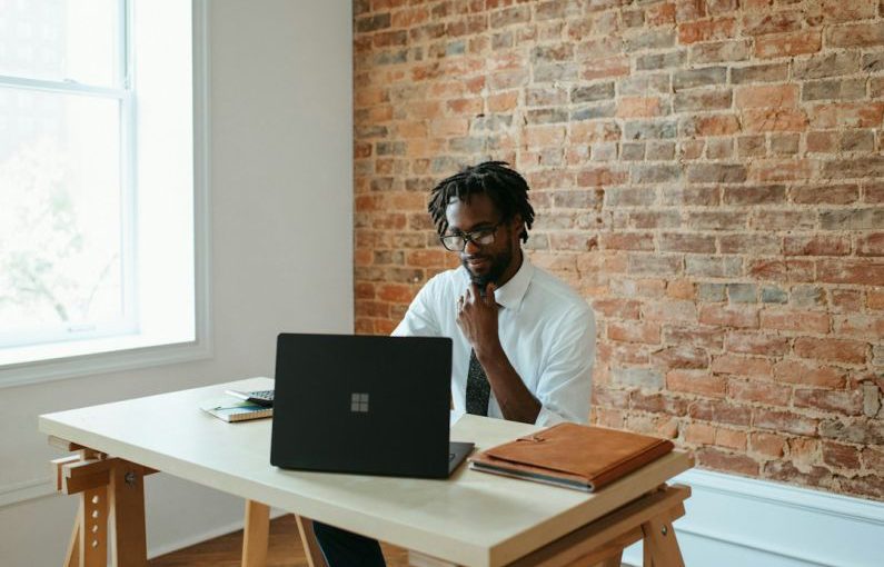 Business - a man sitting at a table in front of a laptop