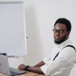Startup - a man sitting at a table with a laptop in front of him