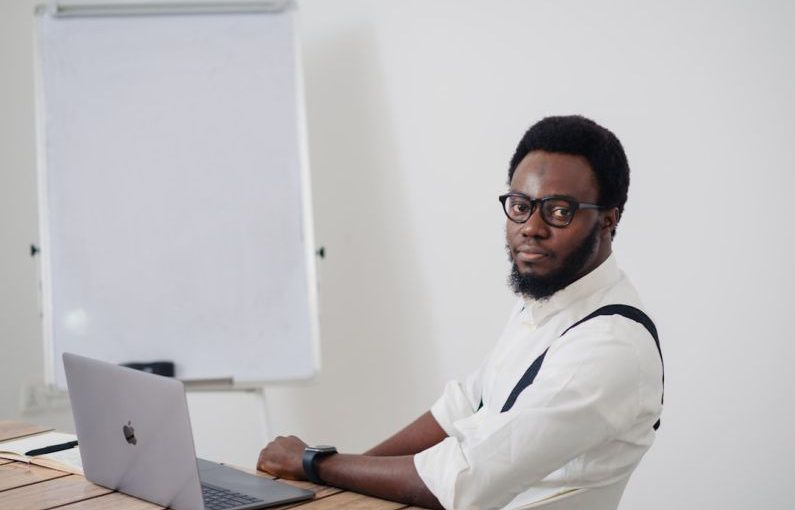 Startup - a man sitting at a table with a laptop in front of him