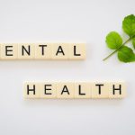 Mental Health - the word mental health spelled with scrabbles next to a green leaf