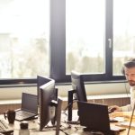 Customer Service - Man With Headphones Facing Computer Monitor