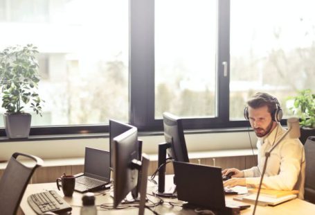 Customer Service - Man With Headphones Facing Computer Monitor