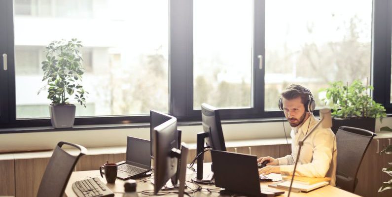 Customer Service - Man With Headphones Facing Computer Monitor