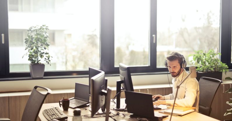 Customer Service - Man With Headphones Facing Computer Monitor