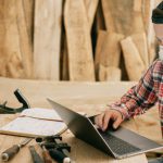 Remote Tools - Man Using a Laptop at a Wood Workshop