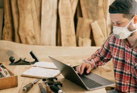 Remote Tools - Man Using a Laptop at a Wood Workshop