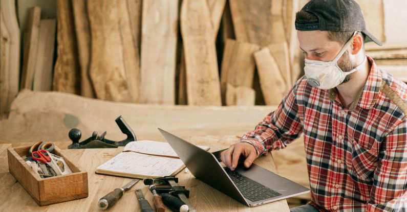 Remote Tools - Man Using a Laptop at a Wood Workshop