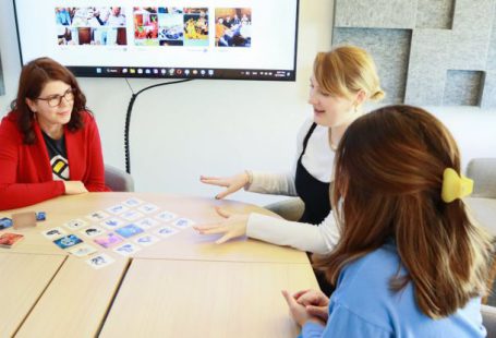 Distributed Team - Three employees playing a board game in a team building activity