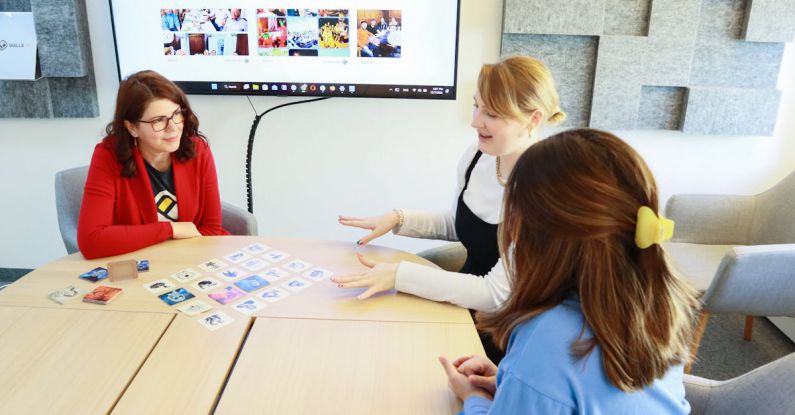 Distributed Team - Three employees playing a board game in a team building activity