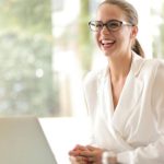 Edtech Startup - Laughing businesswoman working in office with laptop