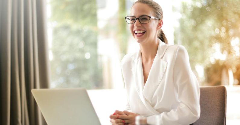 Edtech Startup - Laughing businesswoman working in office with laptop