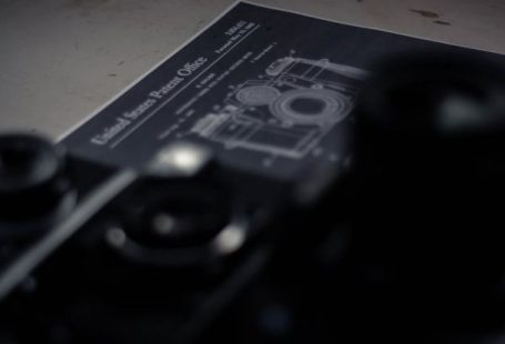 Patent Document - High angle collection of professional retro photo and film cameras arranged on table with patent document