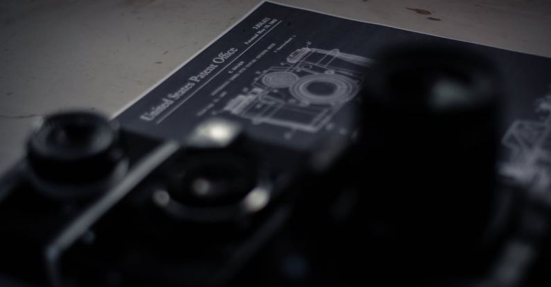 Patent Document - High angle collection of professional retro photo and film cameras arranged on table with patent document